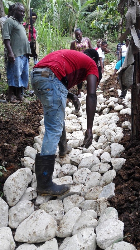 Farmer Stanford Ellis helping to construct a ballasted waterway to minimize soil erosion