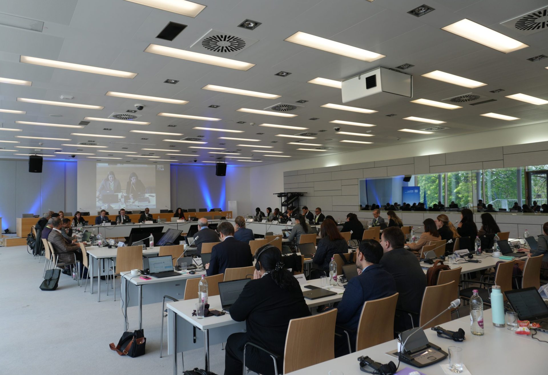 Conference room filled with individuals seated at a large table